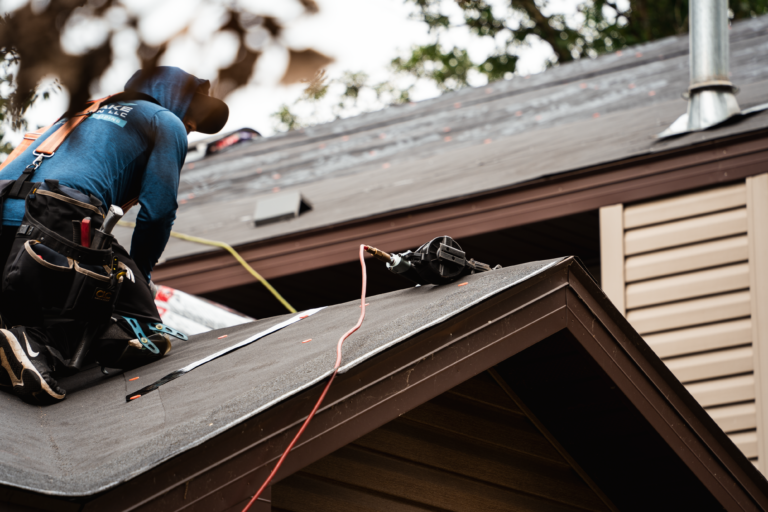 Roofing contractor working on residential roof repair in Elk River, MN, showcasing expert craftsmanship and high-quality materials.
